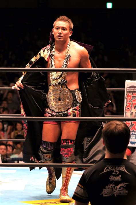 A Man Standing On Top Of A Wrestling Ring Holding A Black Jacket Over