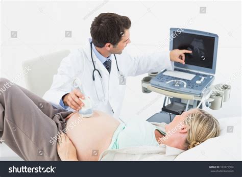 Cheerful Doctor Doing An Ultrasound Scan On Pregnant Woman At The