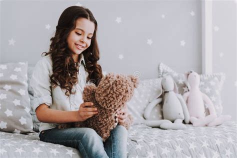 Petite Fille Mignonne S Asseyant Sur Le Lit Tenant Teddy Bear Image