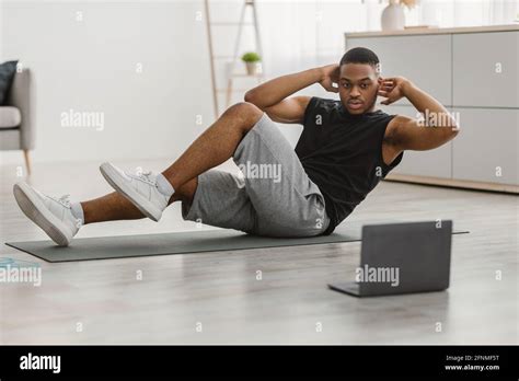 African Guy Doing Elbow To Knee Abs Crunches At Home Stock Photo Alamy