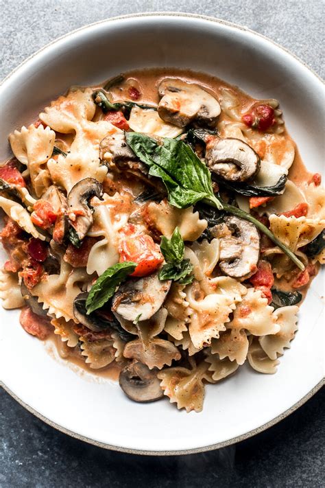 Farfalle Pasta With Spinach And Mushrooms In A Creamy Tomato Sauce