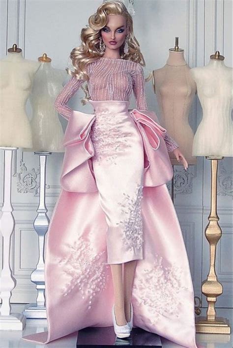 A Barbie Doll Wearing A Pink Dress And Tiara In Front Of Mannequins