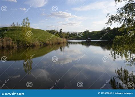 Green Lawns And Trees Over The River And In The River Reflecting Blue