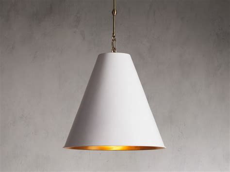 A White Lamp Hanging From A Gold Colored Chain On A Gray Wall With