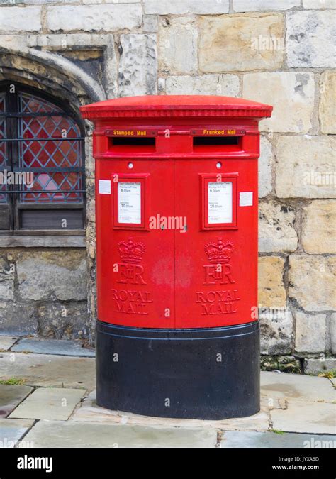 A traditional red double fronted Royal Mail post box with boxes ...