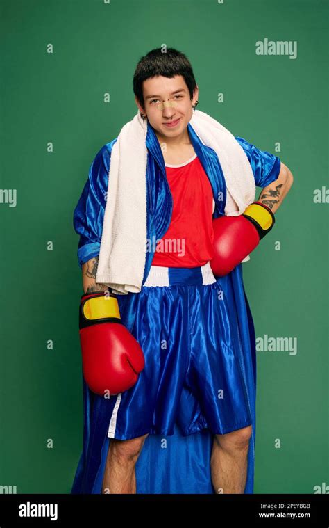 Funny portrait of beginner boxer in robe and shorts posing after fight isolated over green ...