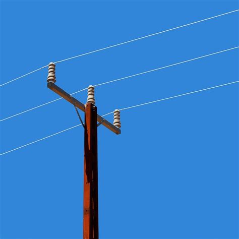 Premium Photo Low Angle View Of Telephone Pole Against Clear Blue Sky