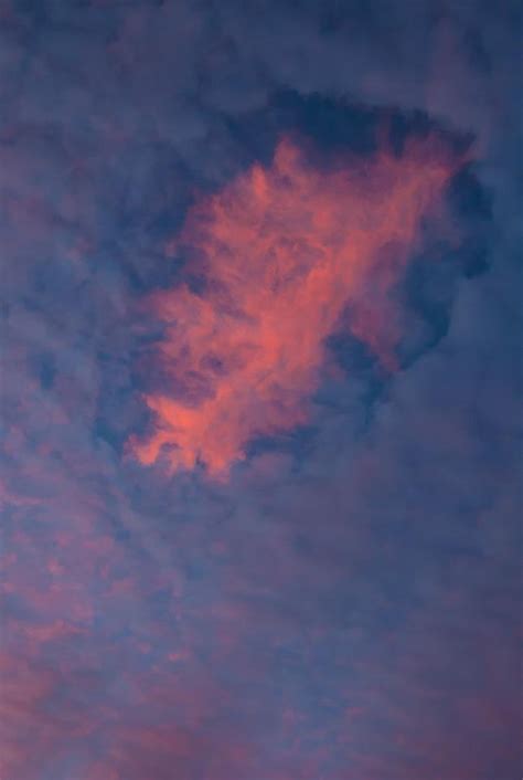 An Airplane Is Flying In The Sky At Sunset Or Dawn With Pink Clouds And