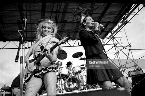 two women are performing on stage with guitars