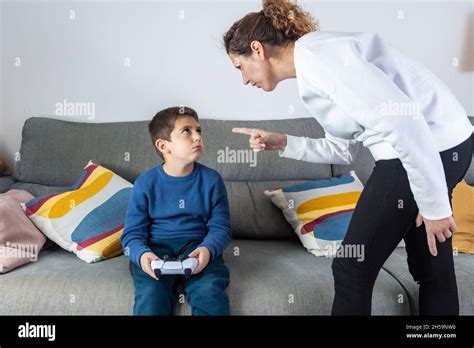 Mother angry with her son because he plays video games Stock Photo - Alamy