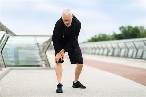 Último homem sofrendo dor no joelho durante treino ao ar livre