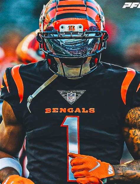 a football player wearing an orange and black uniform with tattoos on ...