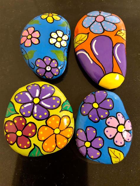 Four Painted Rocks Sitting On Top Of A Table