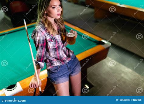 Young Beautiful Woman Having Fun And Playing Billiard In A Club Stock