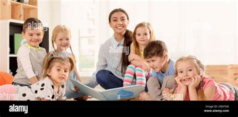 Kindergarten Teacher Reading Book To Children Indoors Banner Design