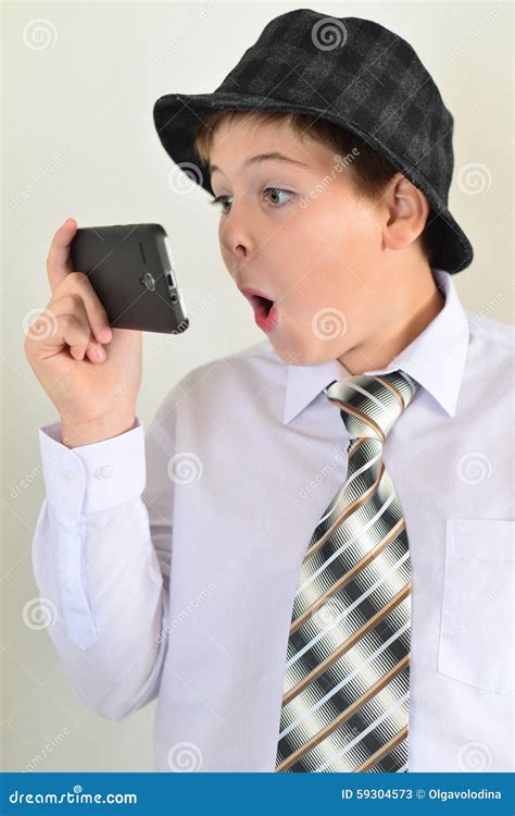 O Menino Adolescente Surpresa Olha O Telefone Celular Imagem De