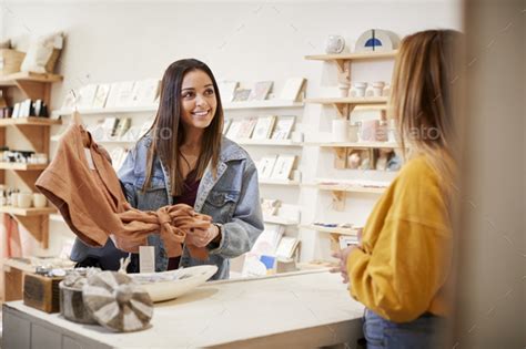 Female Sales Assistant In Independent Clothing And T Store Serving