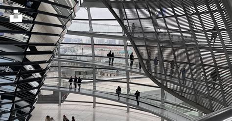 A Group Of People Walking Around Inside Of A Building Photo Free