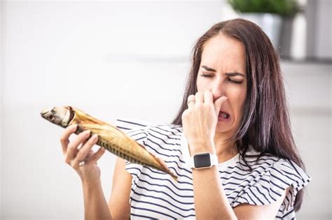 Premium Photo Woman Holds Stinky Fish Holds Her Nose With Disgusted