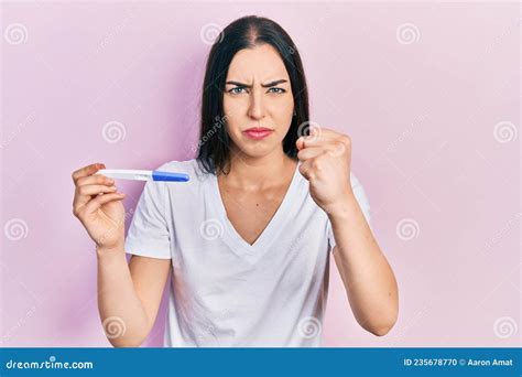 Beautiful Woman With Blue Eyes Holding Pregnancy Test Result Annoyed