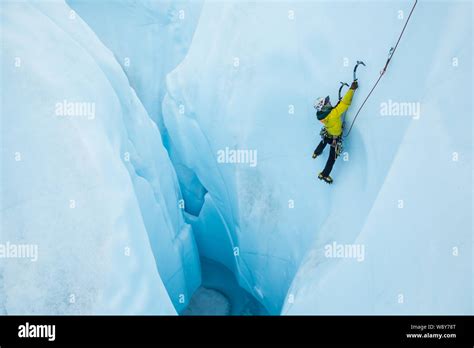 Ice climbing a steep line out of a large hole on glacier ice in Alaska ...