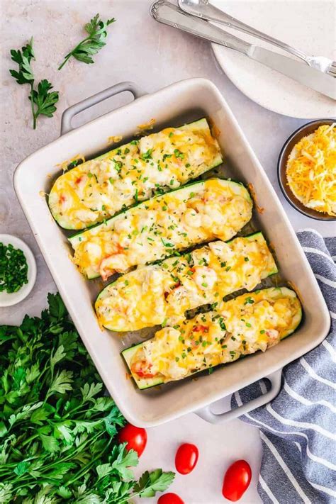 Zucchini Stuffed With Cheese And Parsley In A White Casserole Dish