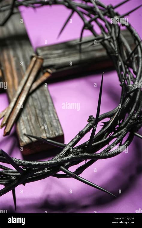 Crown Of Thorns Wooden Cross And Nails On Purple Background Closeup