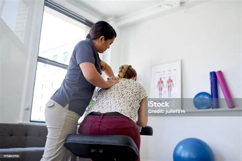 Chinese Woman Massage Therapist Giving A Neck And Back Pressure