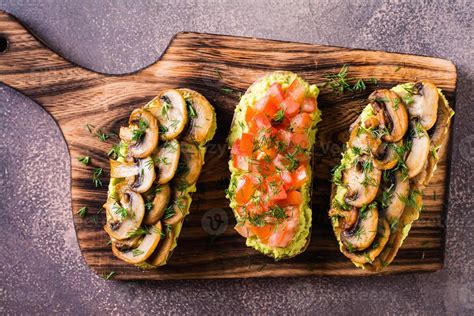 Proche En Haut De Des Sandwichs Avec Avocat Frit Champignons Tomates