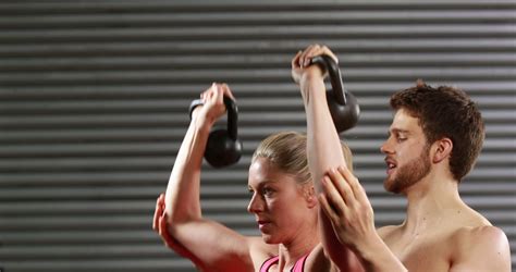 Fit Couple Lifting Kettlebells In Gym For Strength Training From Pikwizard