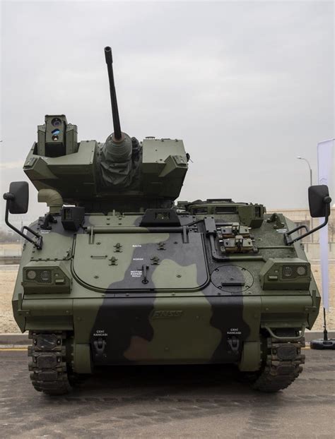 An Army Tank Sitting On Top Of A Parking Lot