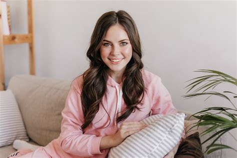 Free Photo Beautiful Portrait Photo Of Cute Brunette Sitting On Her Bright Sofa And Hugging