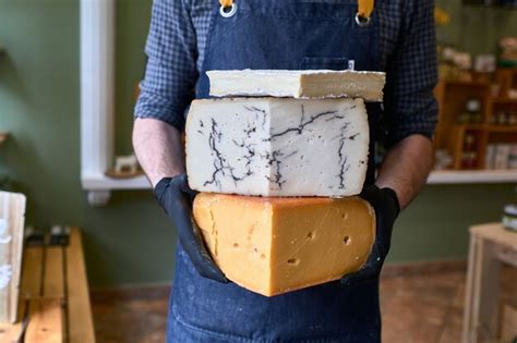 Retrato De Un Vendedor De Queso Guapo En Uniforme Sosteniendo Tres