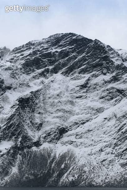 Majestic snow capped mountain peak set against a clear blue sky 이미지