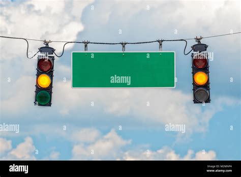 Horizontal Shot Of Two Yellow Traffic Lights Hanging From A Cable With