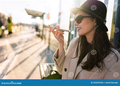 Girl Talking On The Phone On The Speaker While Sitting At The Bus Stop