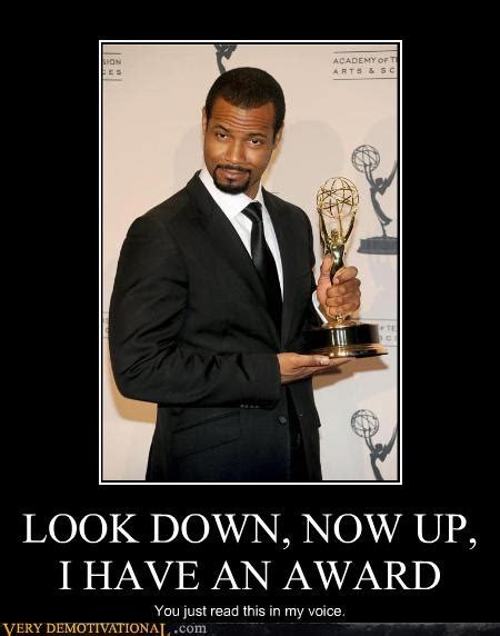 A Man In A Suit And Tie Holding An Award For His Role In The Show