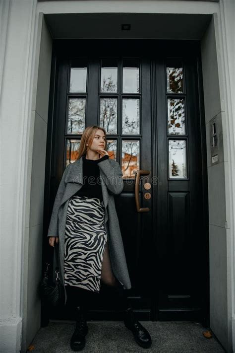 Stylish Girl Standing In The Front Of Old Massive Wooden Door A