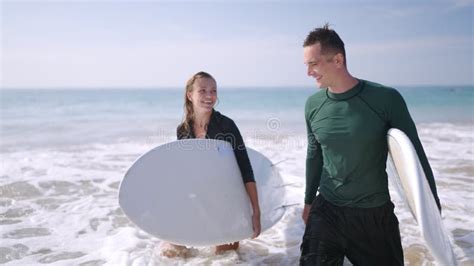 Happy Surfers Couple In Love Coming Out Of Ocean Waves Satisfied With