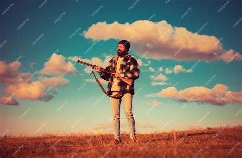 premium photo bearded hunter man holding gun  walking  forest