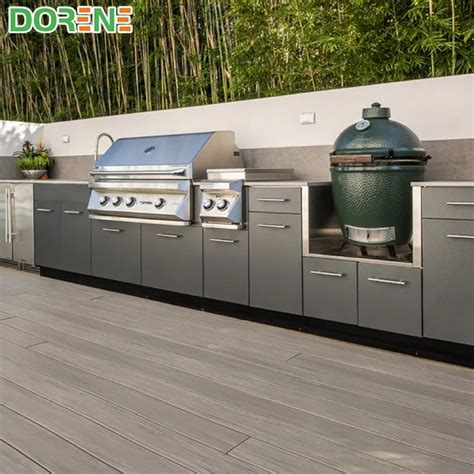 An Outdoor Kitchen With Stainless Steel Cabinets And Grills