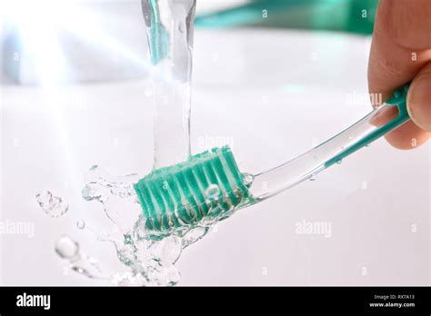 Daily Cleaning Of The Toothbrush After Use In The Bathroom Sink