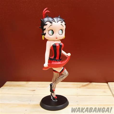 A Figurine That Is On Top Of A Wooden Table Next To A Red Wall