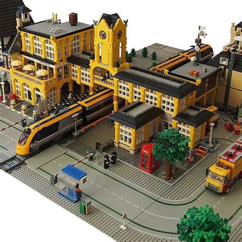 a lego model of a train station with yellow buildings and people ...