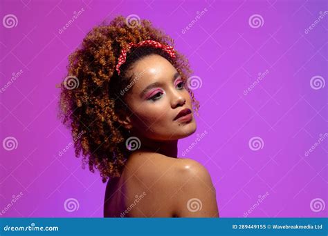 Biracial Woman With Curly Hair Pink Eye Shadow And Lipstick On Purple