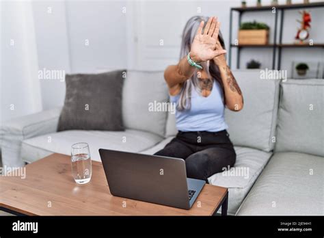 Mujer de pelo gris de mediana edad que usa el portátil en casa