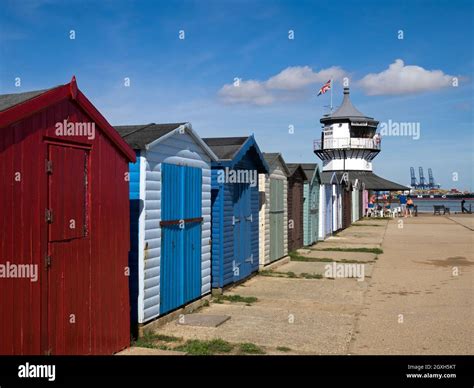 Row Of Colourful Beach Huts With Harwich Low Lighthouse Maritime