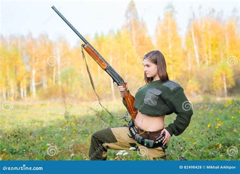 Portrait Of A Beautiful Young Girl In Camouflage Hunter With Shotgun