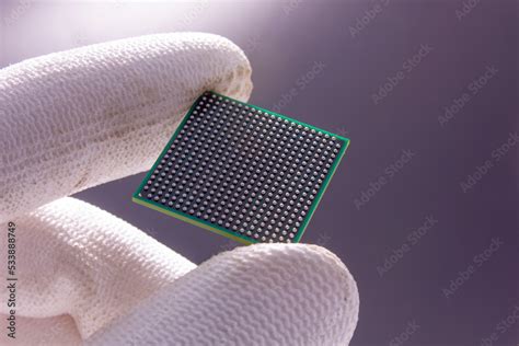 Semiconductor BGA chip in a hand on a gray background Stock Photo | Adobe Stock