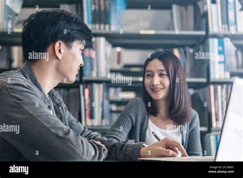 High School Or College Students Studying And Reading Together In